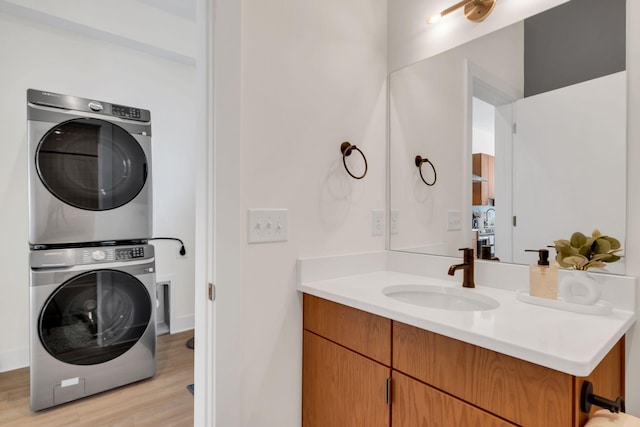 bathroom featuring vanity, stacked washing maching and dryer, and wood-type flooring