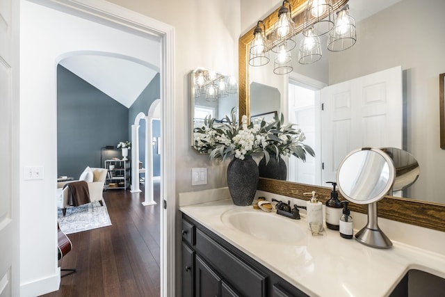 bathroom featuring vanity, hardwood / wood-style flooring, and vaulted ceiling