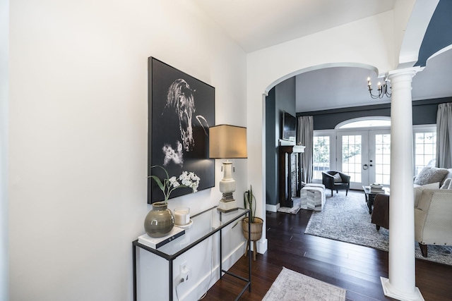 entryway featuring ornate columns, dark hardwood / wood-style flooring, french doors, and a notable chandelier