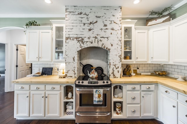 kitchen with butcher block countertops, electric range, and white cabinets