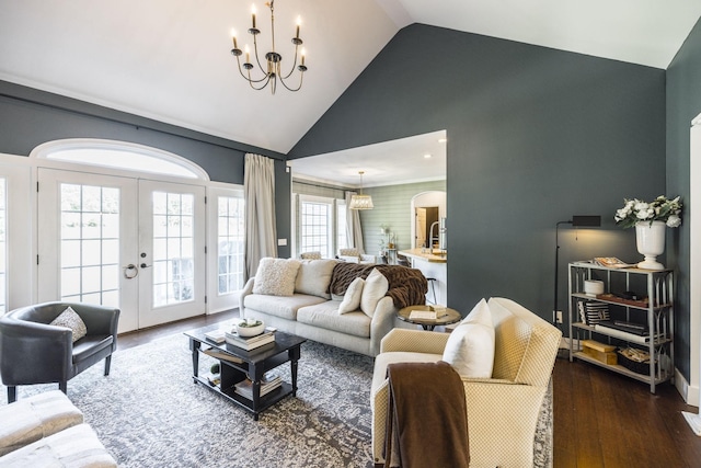 living room with high vaulted ceiling, dark wood-type flooring, a chandelier, and french doors