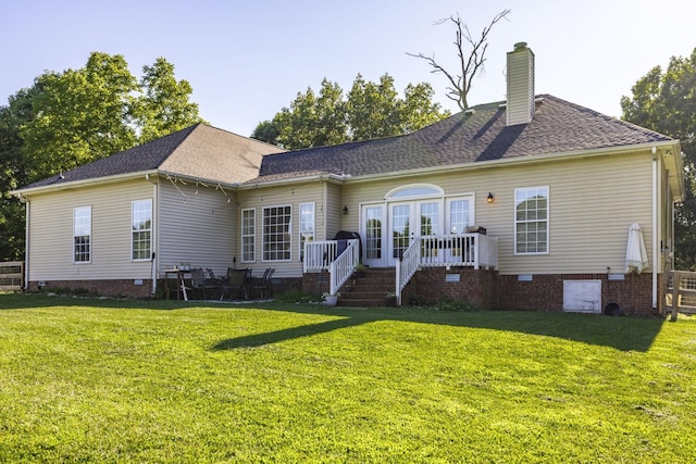 back of property with a yard and french doors