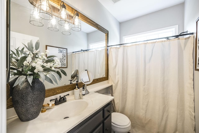 bathroom featuring vanity, curtained shower, and toilet