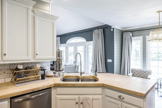 kitchen with butcher block counters, dishwasher, white cabinets, and sink