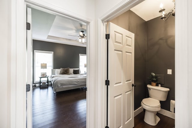 bathroom featuring ceiling fan, wood-type flooring, toilet, and a raised ceiling