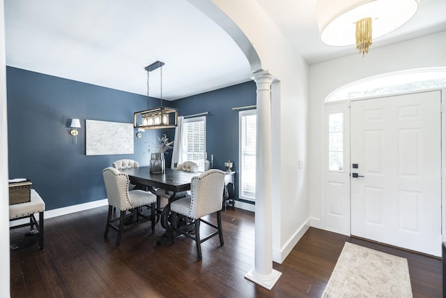 foyer entrance with dark hardwood / wood-style floors and ornate columns