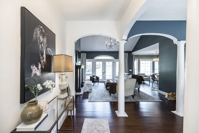 entryway featuring a notable chandelier, dark hardwood / wood-style flooring, ornate columns, and french doors