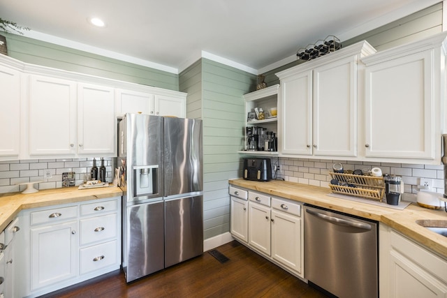 kitchen with tasteful backsplash, appliances with stainless steel finishes, white cabinets, and wood counters