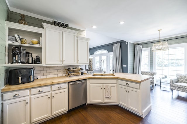 kitchen with pendant lighting, sink, white cabinetry, butcher block counters, and stainless steel dishwasher