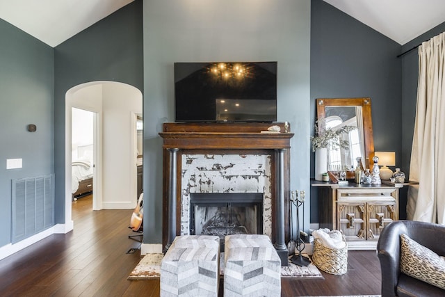 living room with hardwood / wood-style flooring, a fireplace, and high vaulted ceiling