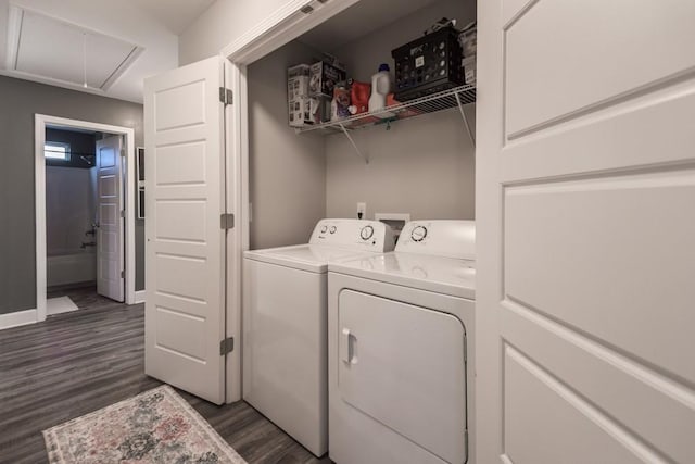 clothes washing area with dark hardwood / wood-style floors and washing machine and clothes dryer