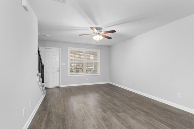 empty room with ceiling fan and dark wood-type flooring