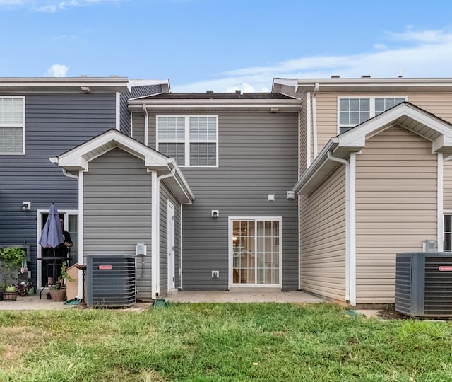 back of property with a yard, cooling unit, and a patio