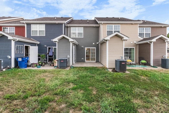 back of property with a yard, cooling unit, and a patio