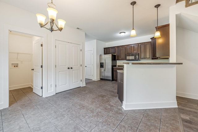 kitchen with dark brown cabinetry, stainless steel refrigerator with ice dispenser, kitchen peninsula, a chandelier, and decorative light fixtures