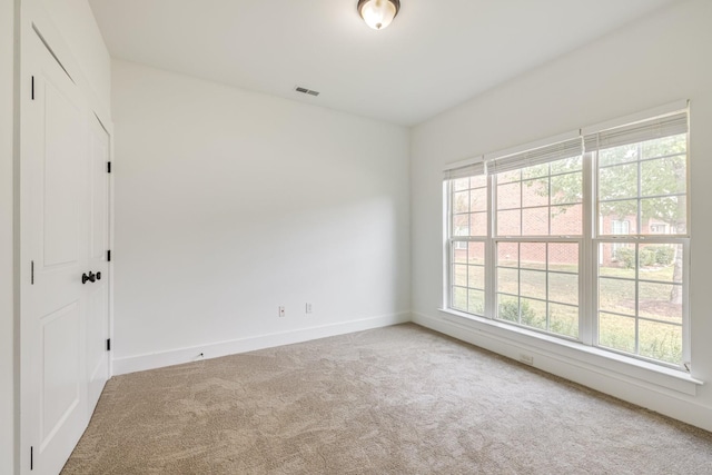 carpeted spare room featuring plenty of natural light