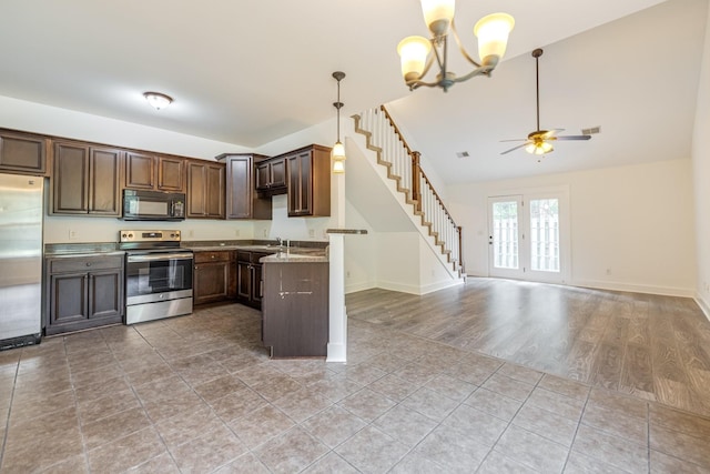 kitchen featuring pendant lighting, ceiling fan with notable chandelier, light stone countertops, dark brown cabinetry, and stainless steel appliances