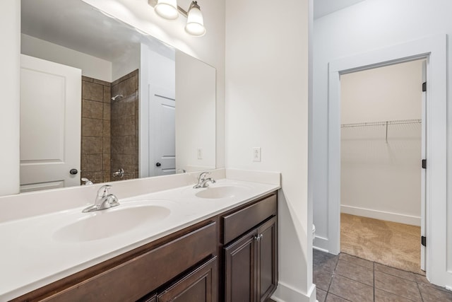 bathroom featuring tile patterned flooring, vanity, and tiled shower