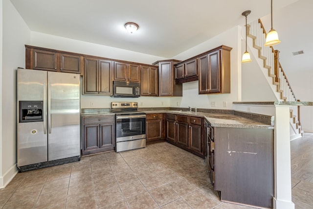 kitchen featuring decorative light fixtures, dark brown cabinetry, sink, and appliances with stainless steel finishes