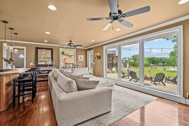 living room with ceiling fan, dark hardwood / wood-style flooring, and ornamental molding