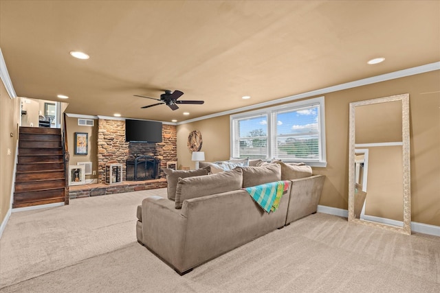 living room with carpet flooring, a stone fireplace, ceiling fan, and crown molding