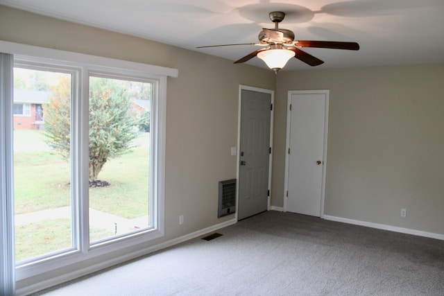 carpeted empty room with heating unit and ceiling fan