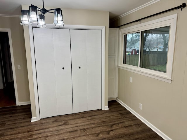 unfurnished bedroom featuring dark hardwood / wood-style floors, a closet, and crown molding