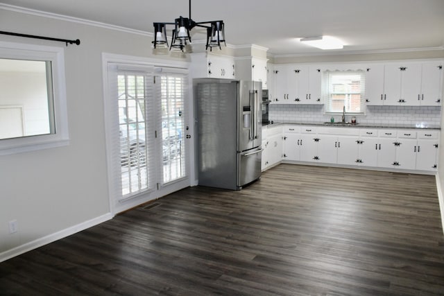 kitchen with white cabinets, stainless steel refrigerator with ice dispenser, decorative backsplash, and hanging light fixtures