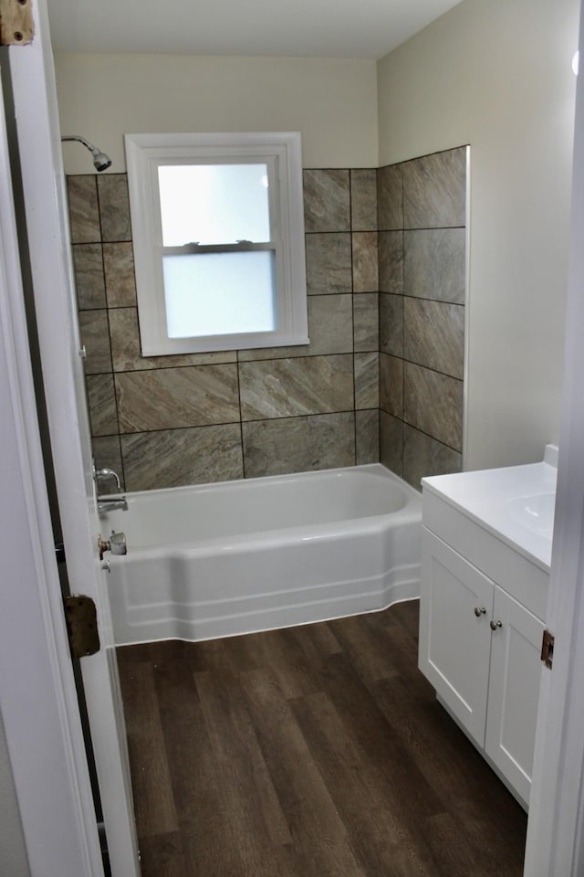 bathroom featuring hardwood / wood-style floors, vanity, and tiled shower / bath