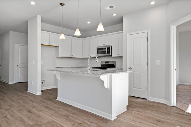 kitchen with white cabinetry, a center island with sink, and stainless steel appliances