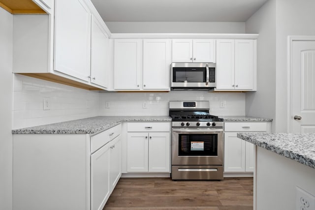 kitchen featuring backsplash, light stone countertops, white cabinets, and appliances with stainless steel finishes