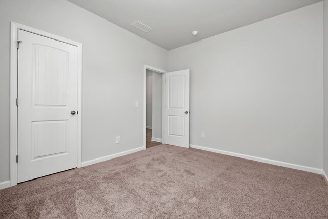 unfurnished bedroom featuring carpet and a closet