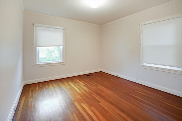 empty room featuring hardwood / wood-style flooring and ornamental molding