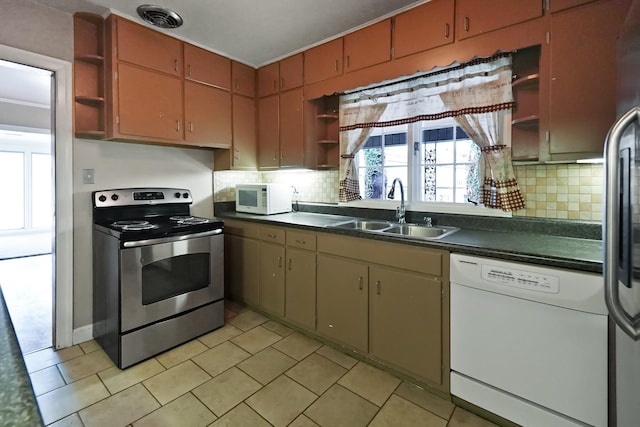 kitchen featuring tasteful backsplash, sink, light tile patterned floors, and stainless steel appliances