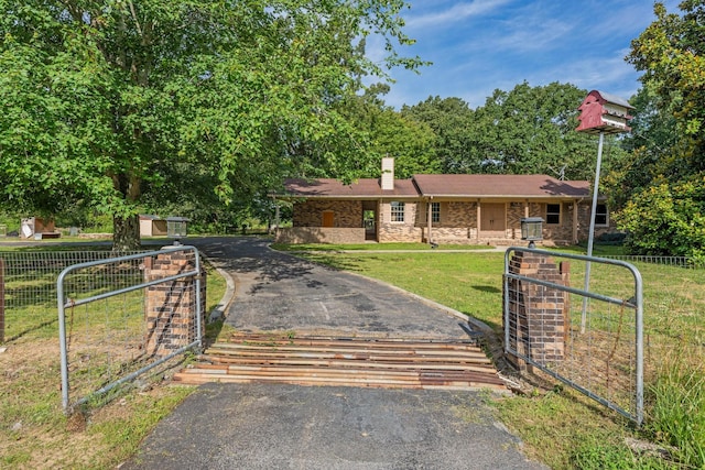 view of front facade featuring a front lawn and a storage shed