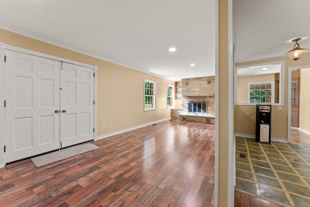 unfurnished living room featuring a fireplace, dark hardwood / wood-style floors, and ornamental molding