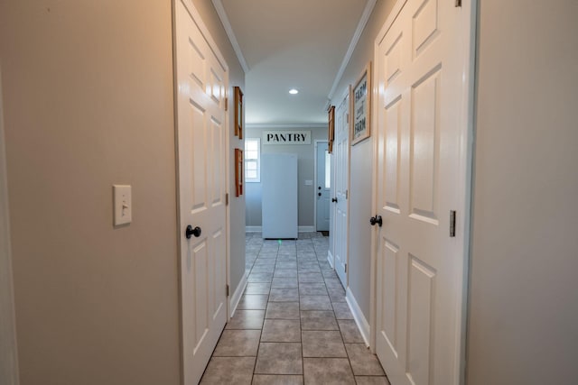 hallway featuring light tile patterned floors and ornamental molding