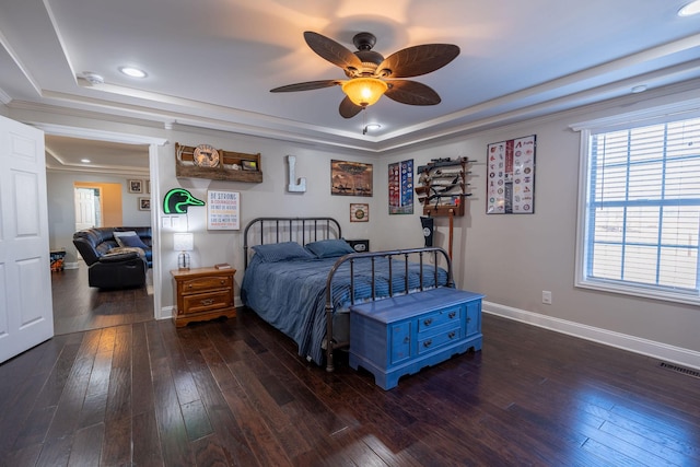 bedroom featuring a tray ceiling, ceiling fan, and dark wood-type flooring