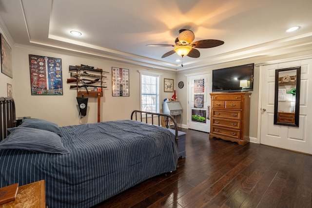 bedroom with ceiling fan, dark hardwood / wood-style flooring, and a raised ceiling