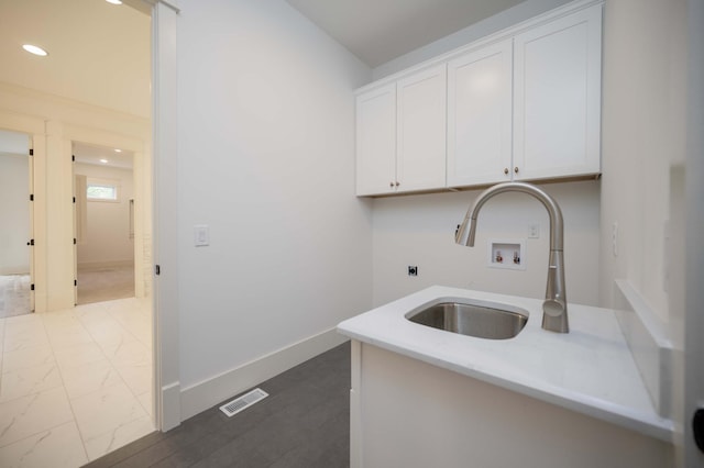 laundry room with cabinets, hookup for a washing machine, hookup for an electric dryer, and sink