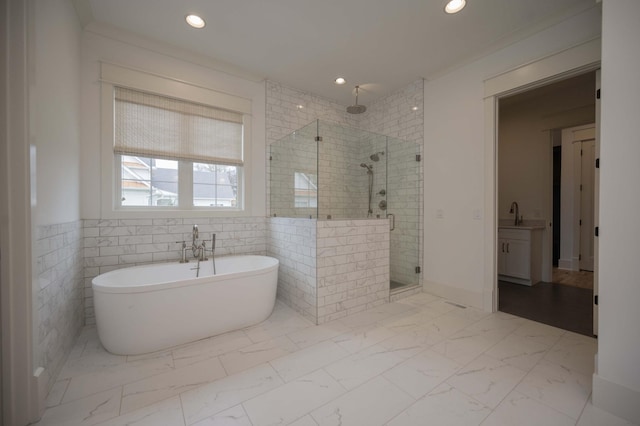 bathroom featuring plus walk in shower, vanity, and tile walls