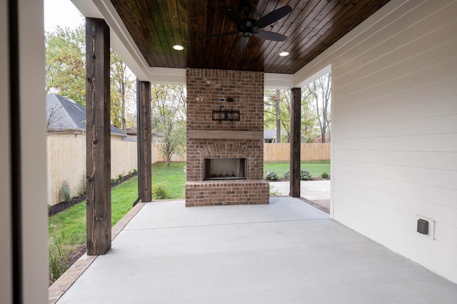 view of patio featuring an outdoor brick fireplace and ceiling fan