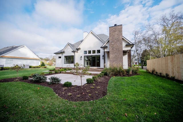 rear view of property with a patio area and a lawn