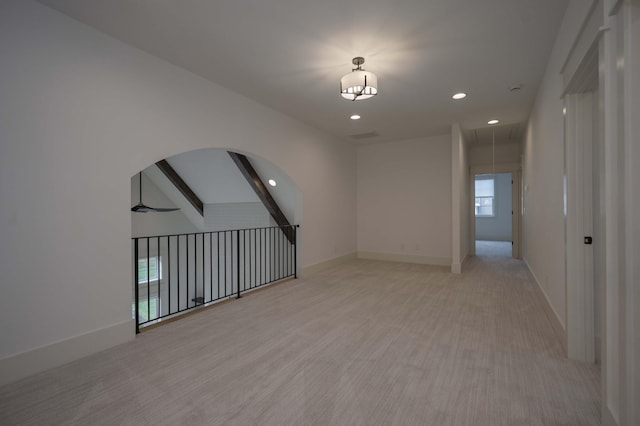 interior space with beam ceiling and light colored carpet