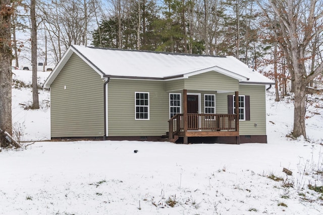 view of snow covered back of property