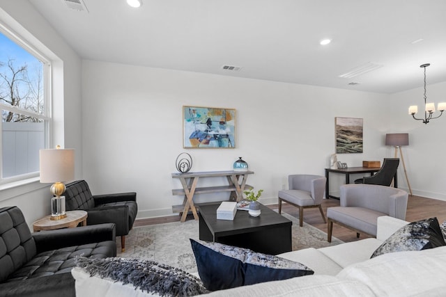 living room with hardwood / wood-style floors and a notable chandelier