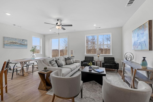 living room featuring light hardwood / wood-style floors and ceiling fan