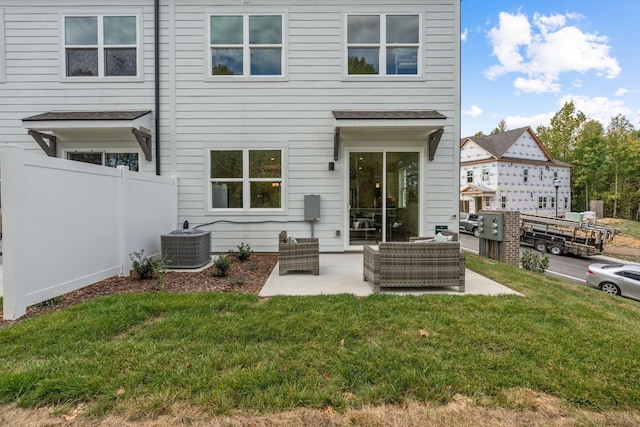 rear view of property with central AC, a patio area, and a lawn