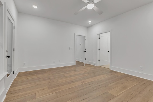 empty room with ceiling fan and light hardwood / wood-style floors