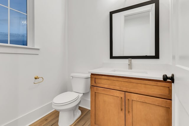 bathroom with wood-type flooring, vanity, and toilet